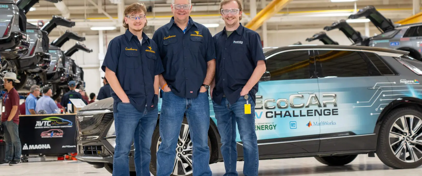 Image of three males with white skin posing in front of an EcoCAR-branded vehicle.