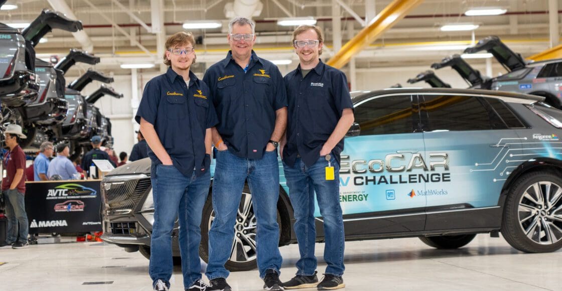 Image of three males with white skin posing in front of an EcoCAR-branded vehicle.